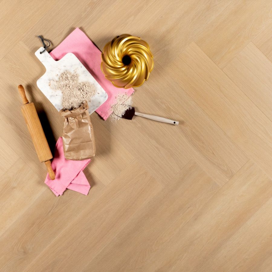 Lichte eikenkleurige vloer in visgraat met bakspullen en een gouden tulbandvorm