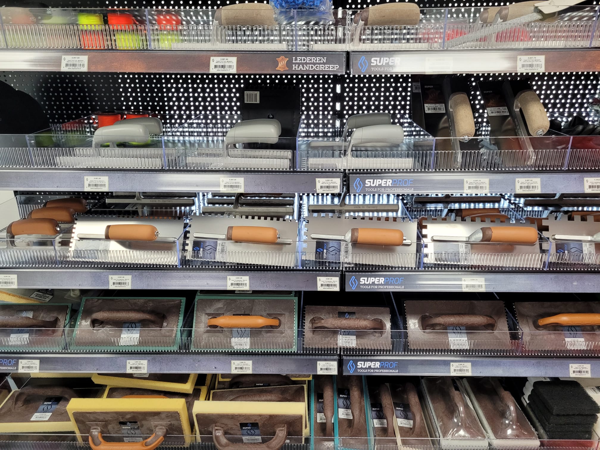 Schappen met troffels, voegspanen en ander gereedschap voor tegelwerk in de winkel van Tegelhal Verschuur