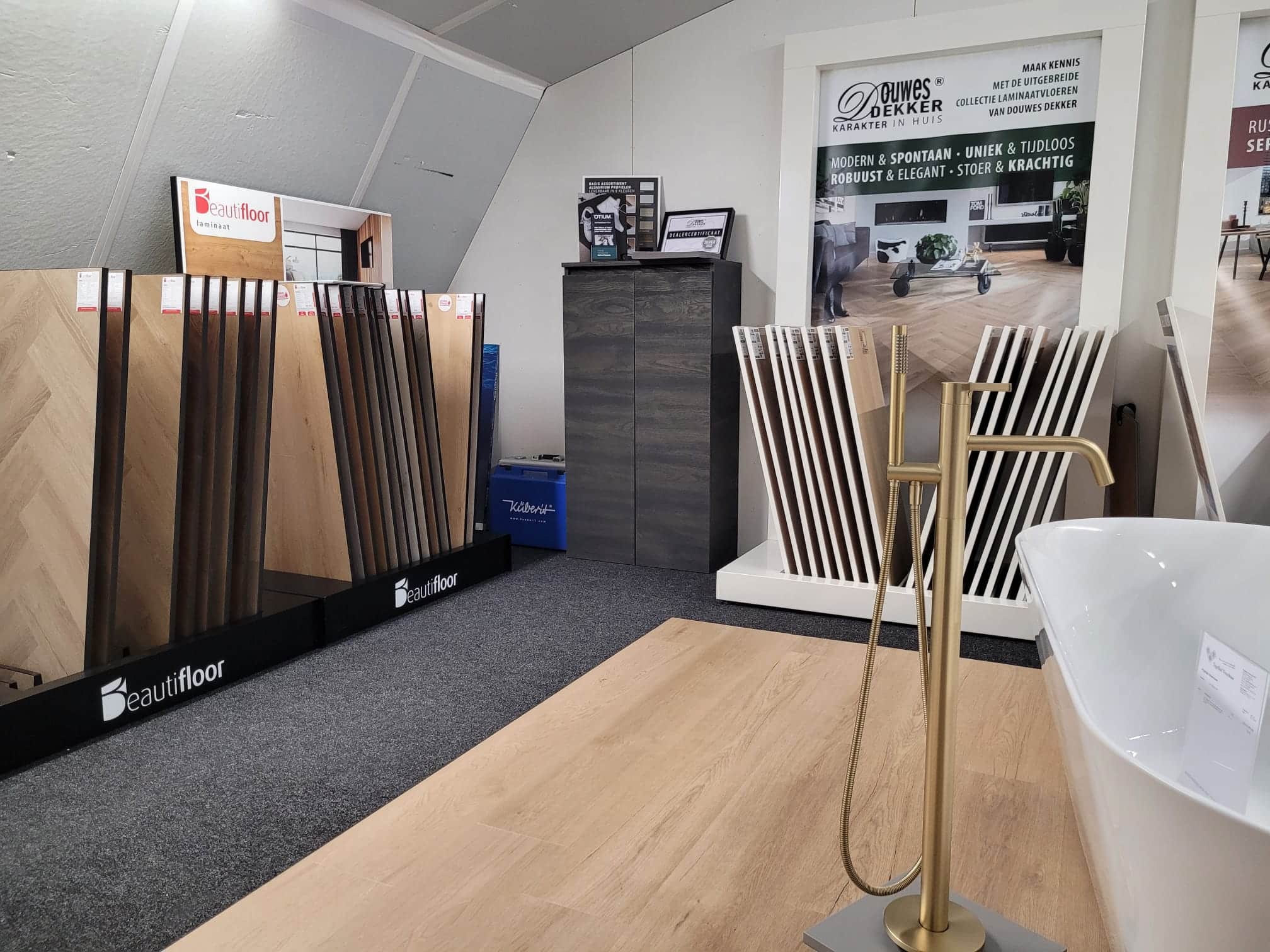 Vloerstalen in houtlook en een vrijstaand bad met koperen kraan in de showroom