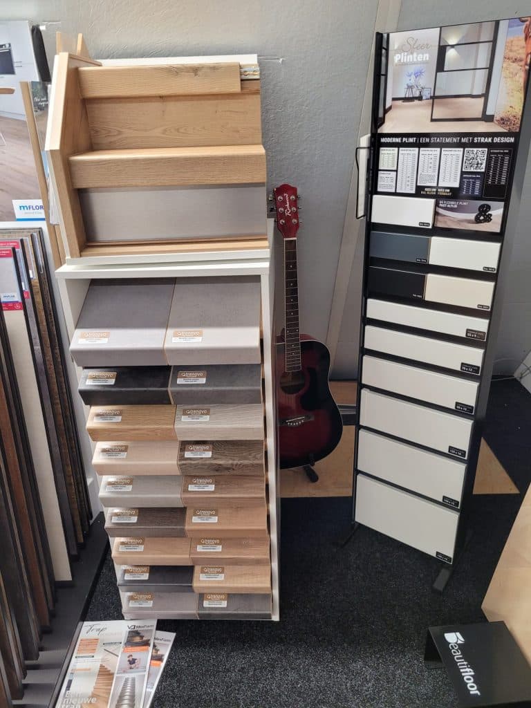 Rek met vloerstalen in houtlook en grijstinten in de showroom van Tegelhal Verschuur