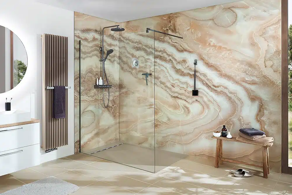 Inloopdouche met een wand in een warme marmerlook, een glazen douchewand en een houten bankje